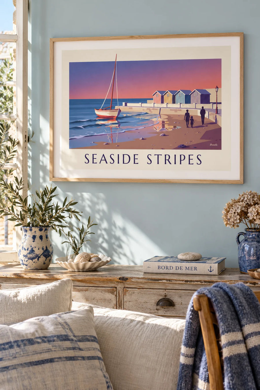 Poster of striped beach huts and a stranded sailboat at dusk: framed on the wall