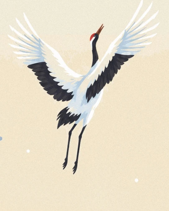 Une grue à calotte rouge, le bec levé et les ailes blanches et noires déployées