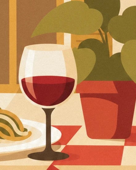 A glass of red wine in front of a plant with green leaves in a red pot