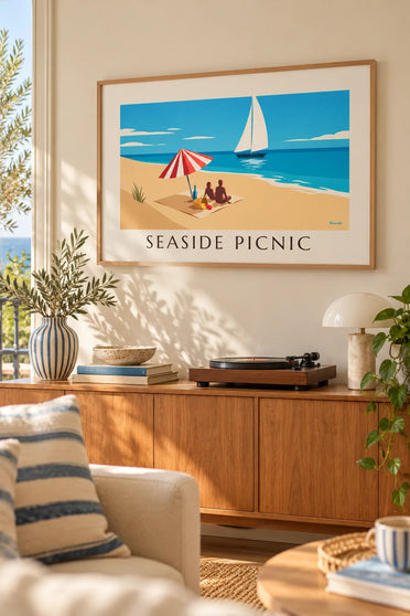 Plakat med picnic ved havet under en stribet parasol: indrammet på væggen