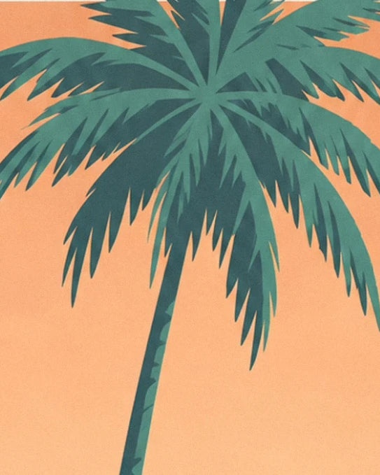 A palm tree with a leaning trunk and long green fronds against an orange sky
