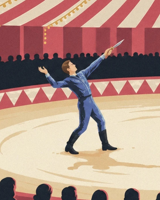 The knife thrower in a blue suit with a knife raised in front of the circus stands