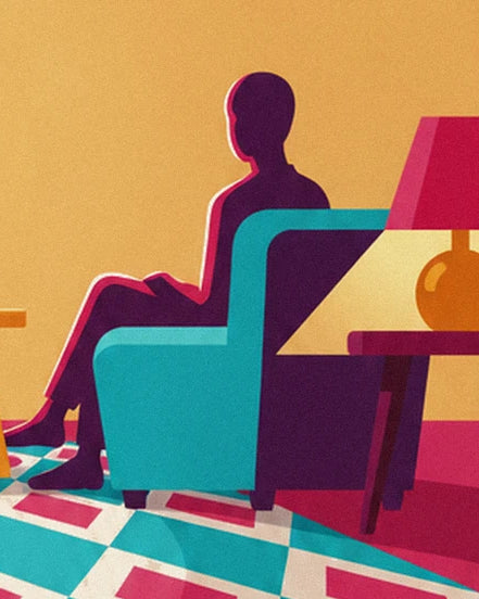 A figure sitting in a turquoise armchair, near a lamp with a pink shade