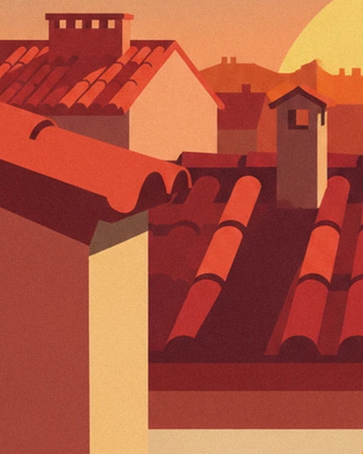 Les toits de tuiles rouges et leur cheminée claire sous le ciel orangé