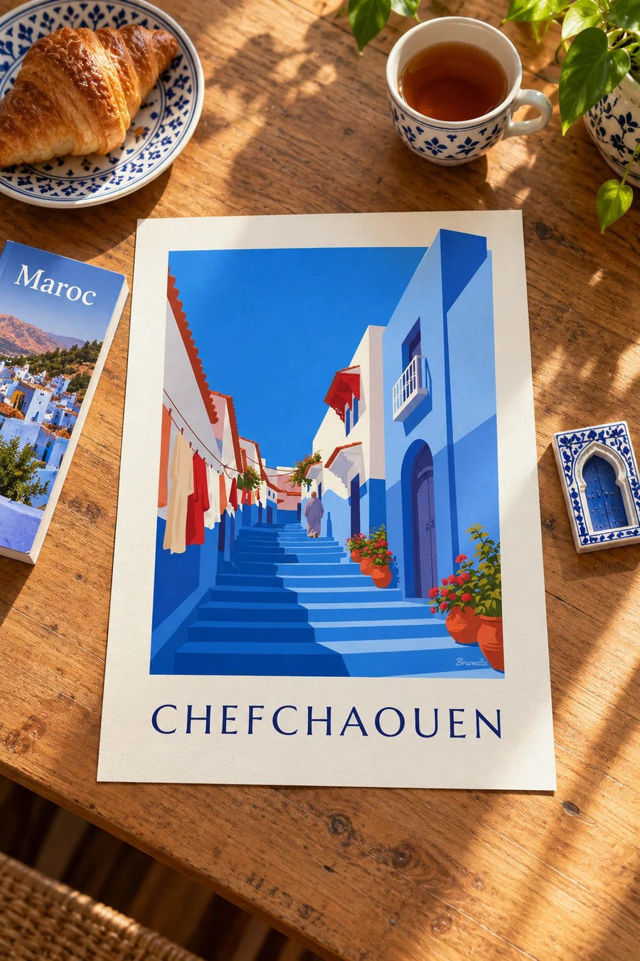 Plakat med Chefchaouens blå gyde i Marokko : stillet på et bord
