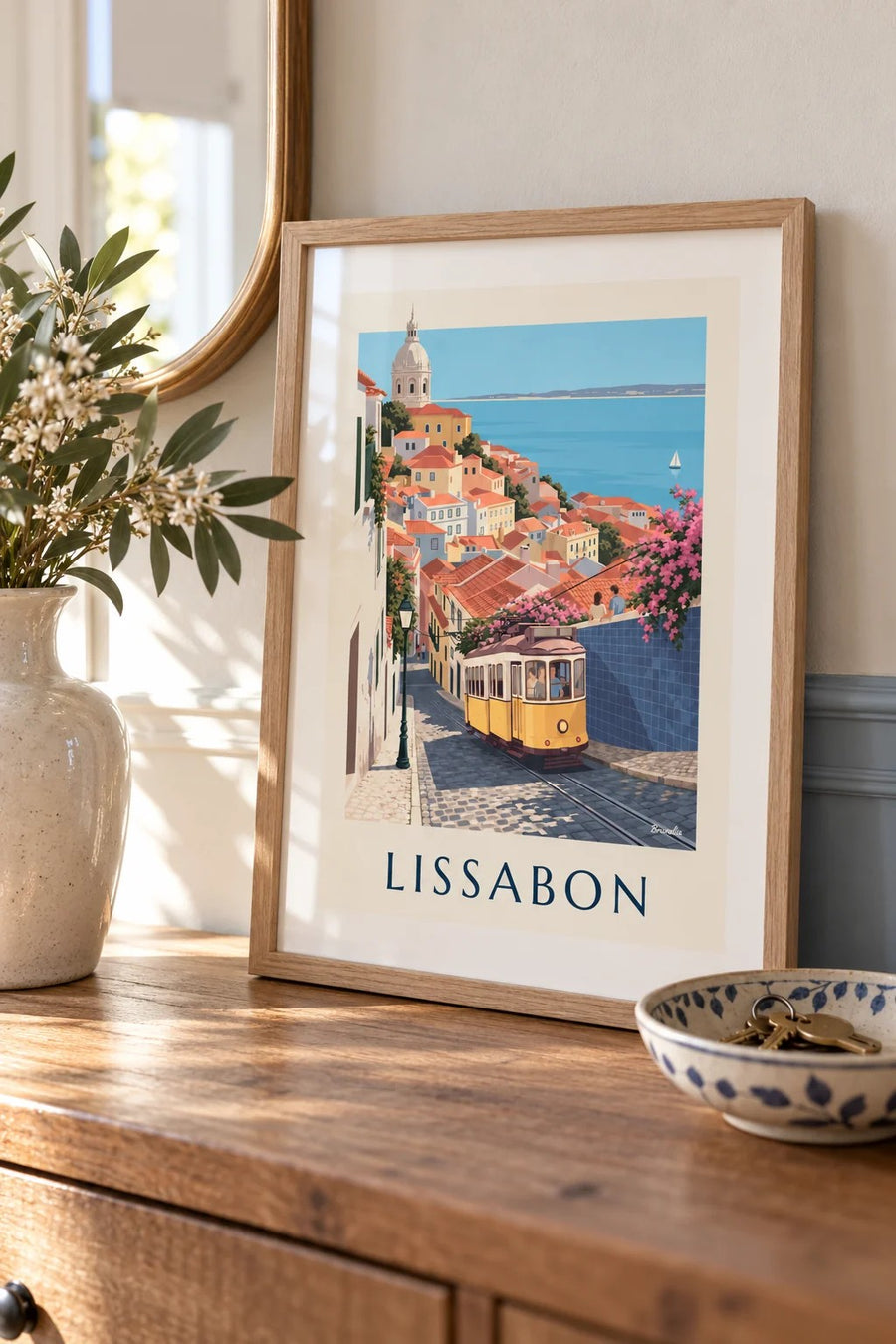 Plakat med gul sporvogn på brostensbelagt gade i Lissabon med udsigt til Tejo: lille A4-plakat i ramme