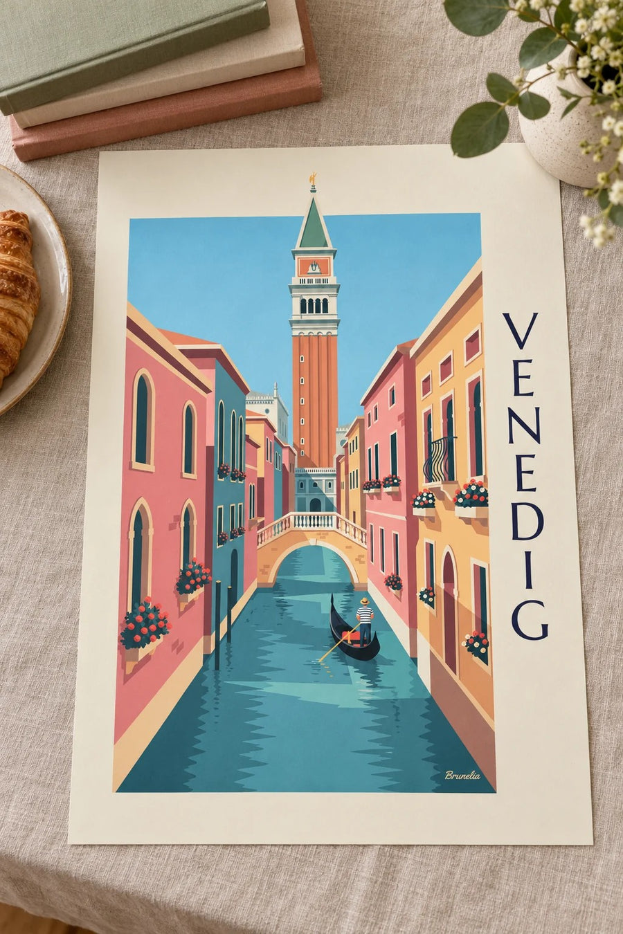 Plakat med gondolier på en lille kanal under Campanilen i Venedig: liggende på et bord
