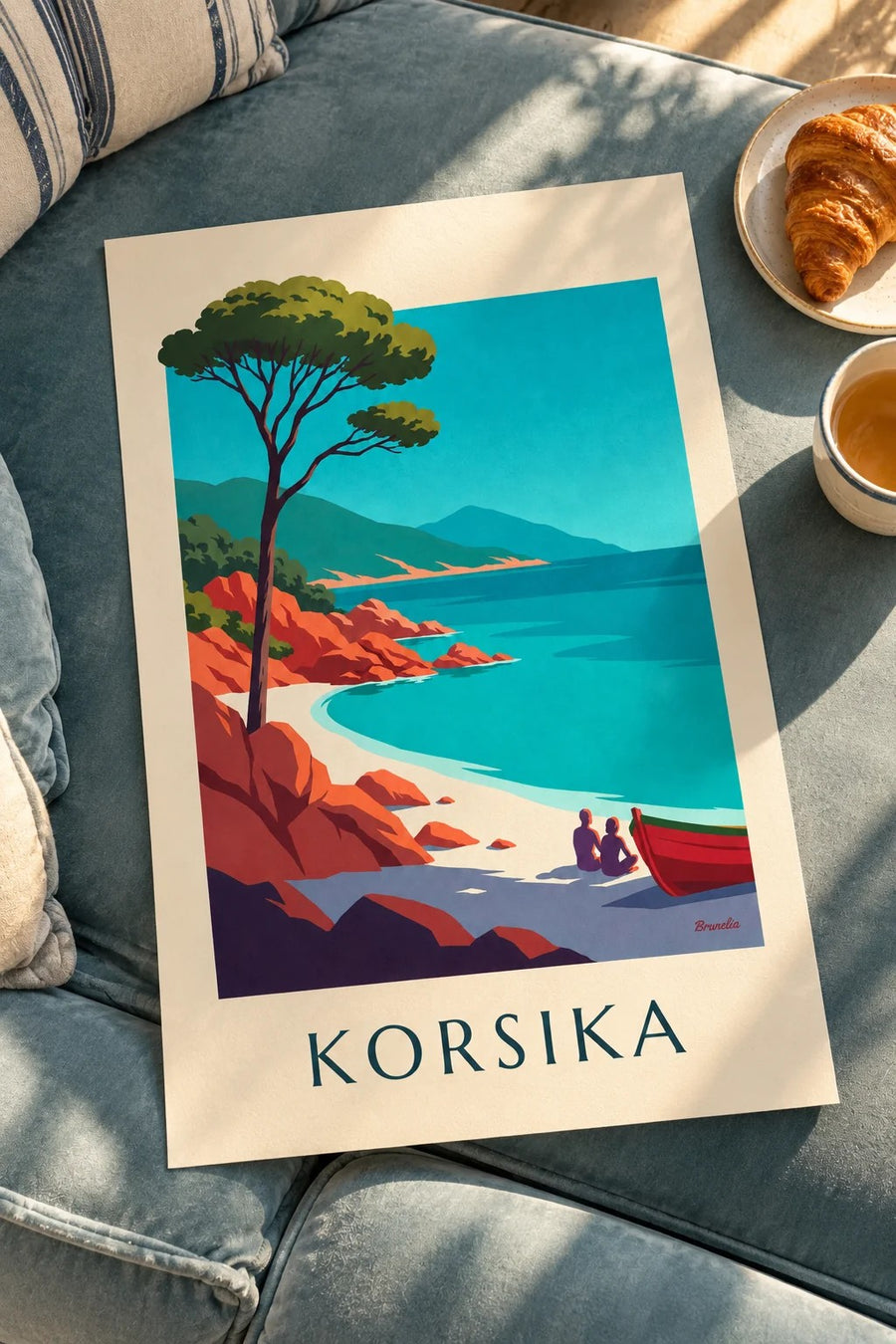 Plakat med bugt på Korsika, røde granitklipper og pinje: på et bord