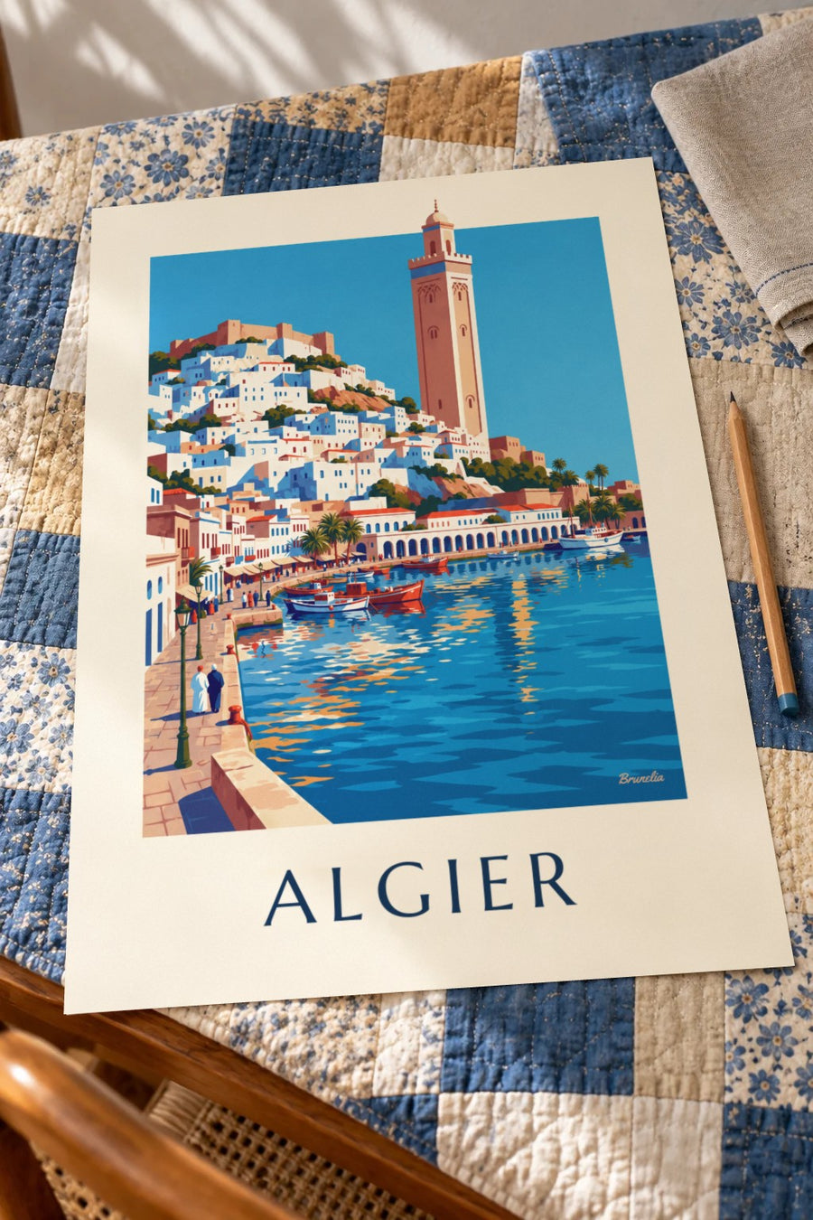 Plakat med Algiers hvide Casbah, der skråner ned mod Middelhavet: lagt fladt på et bord