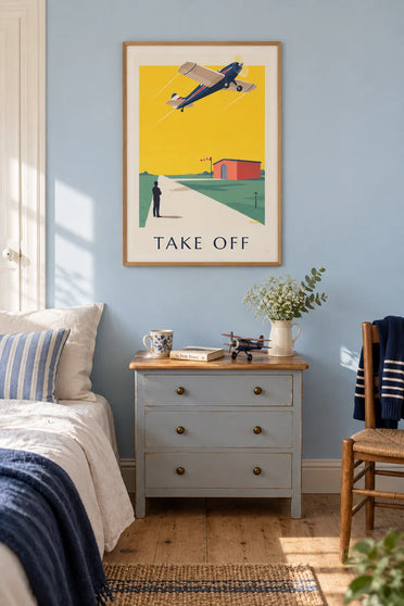 Poster of a propeller plane taking off against a yellow sky: framed on the wall