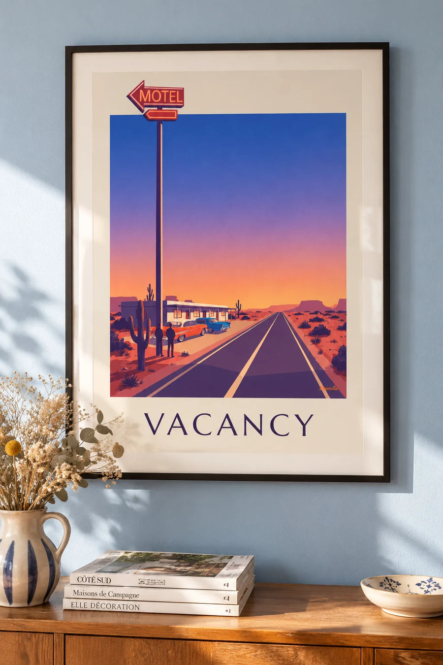 Plakat med motelneonskilt ved en vej i ørkenen: indrammet på væggen