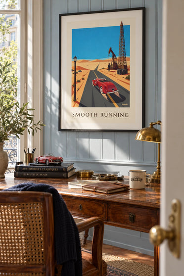 Poster of a roadster on a desert road with an oil derrick: framed on the wall
