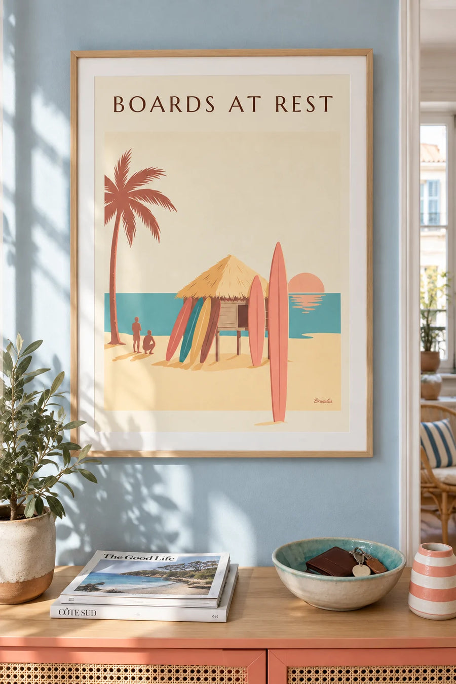 Affiche planches de surf contre une paillote au coucher du soleil : encadrée au mur