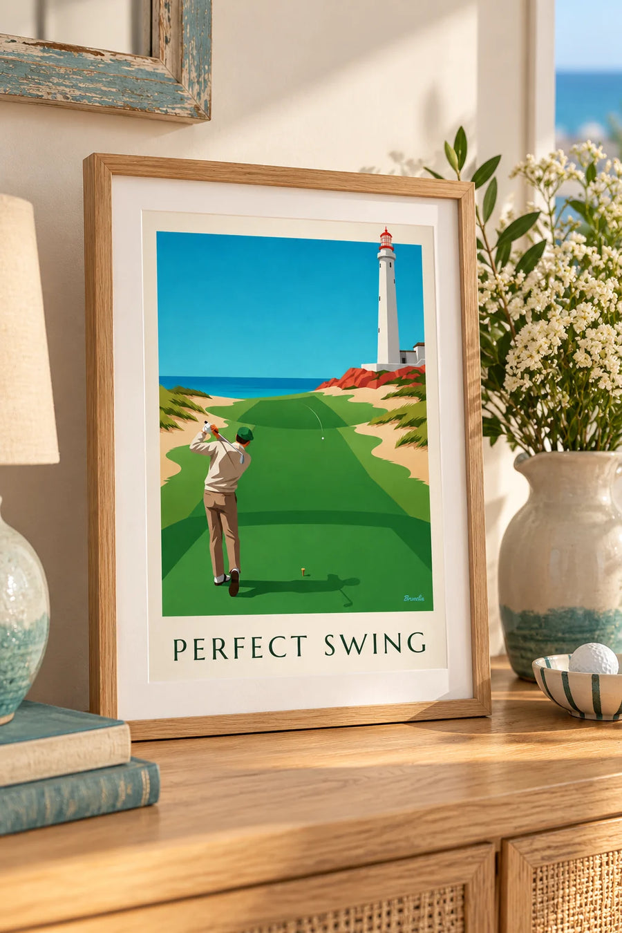 Plakat med golfspiller midt i et sving på en links-bane ved klippekanten: lille A4-format i ramme