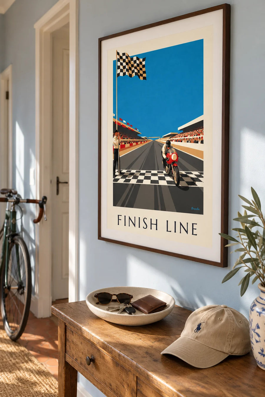Plakat med motorcykel, der krydser målstregen under det ternede flag: indrammet på væggen